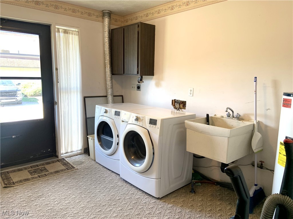 9956 Johnnycake Ridge Road, Unit D9 Painesville, OH 44077 - Photo 5 of 37 Laundry area with cabinet space, water heater, light carpet, and washing machine and clothes dryer