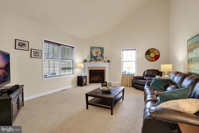 a living room with furniture a fireplace and a large window