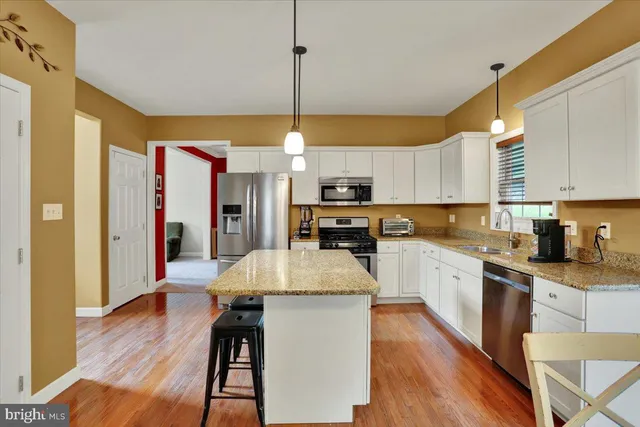 a large kitchen with cabinets wooden floor and stainless steel appliances