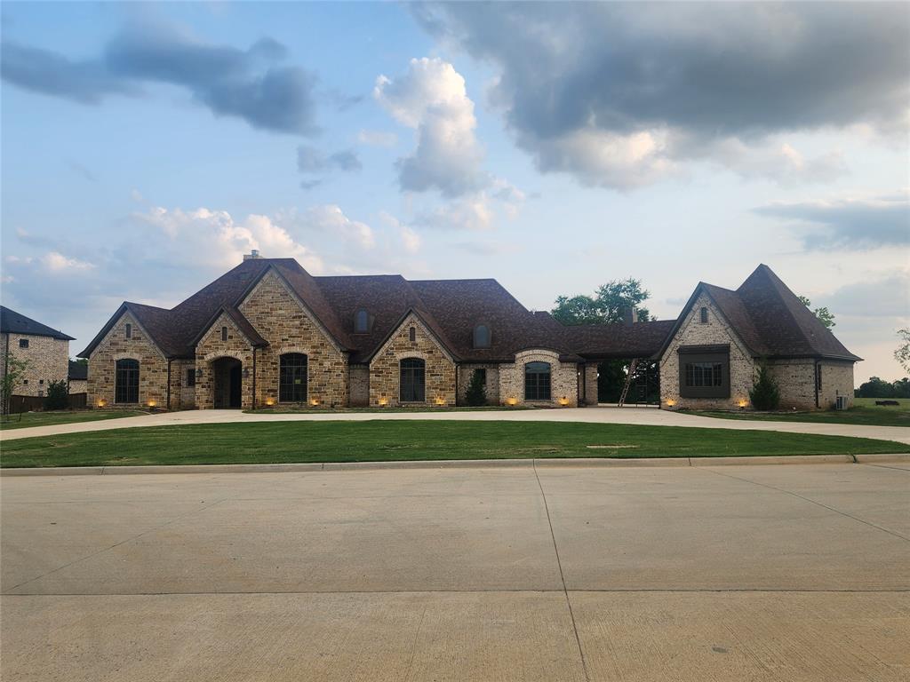 124 Chisolm Trail Pottsboro, TX 75076 - Photo 9 of 15 French country style house featuring curved driveway, a front yard, and stone siding