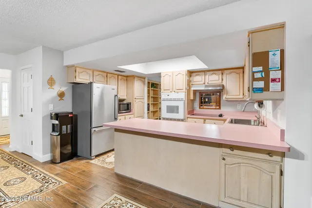 a view of a house with a yard and large tree
