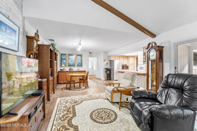 a view of a house with a big yard and large trees