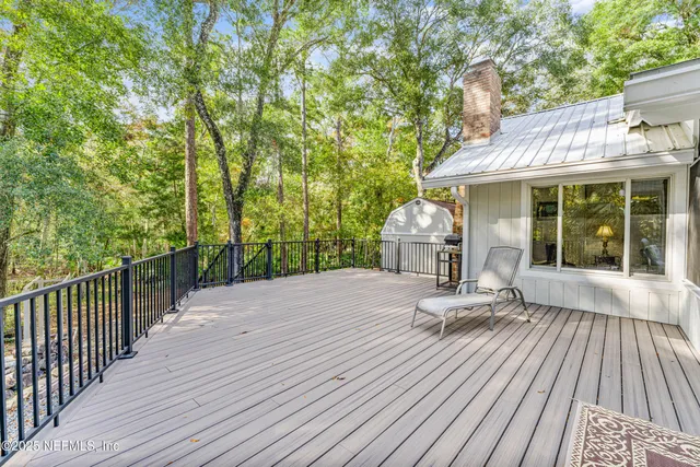 a view of a house with a yard and large tree