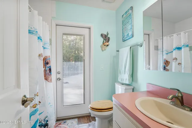 an aerial view of a residential houses with outdoor space and trees all around