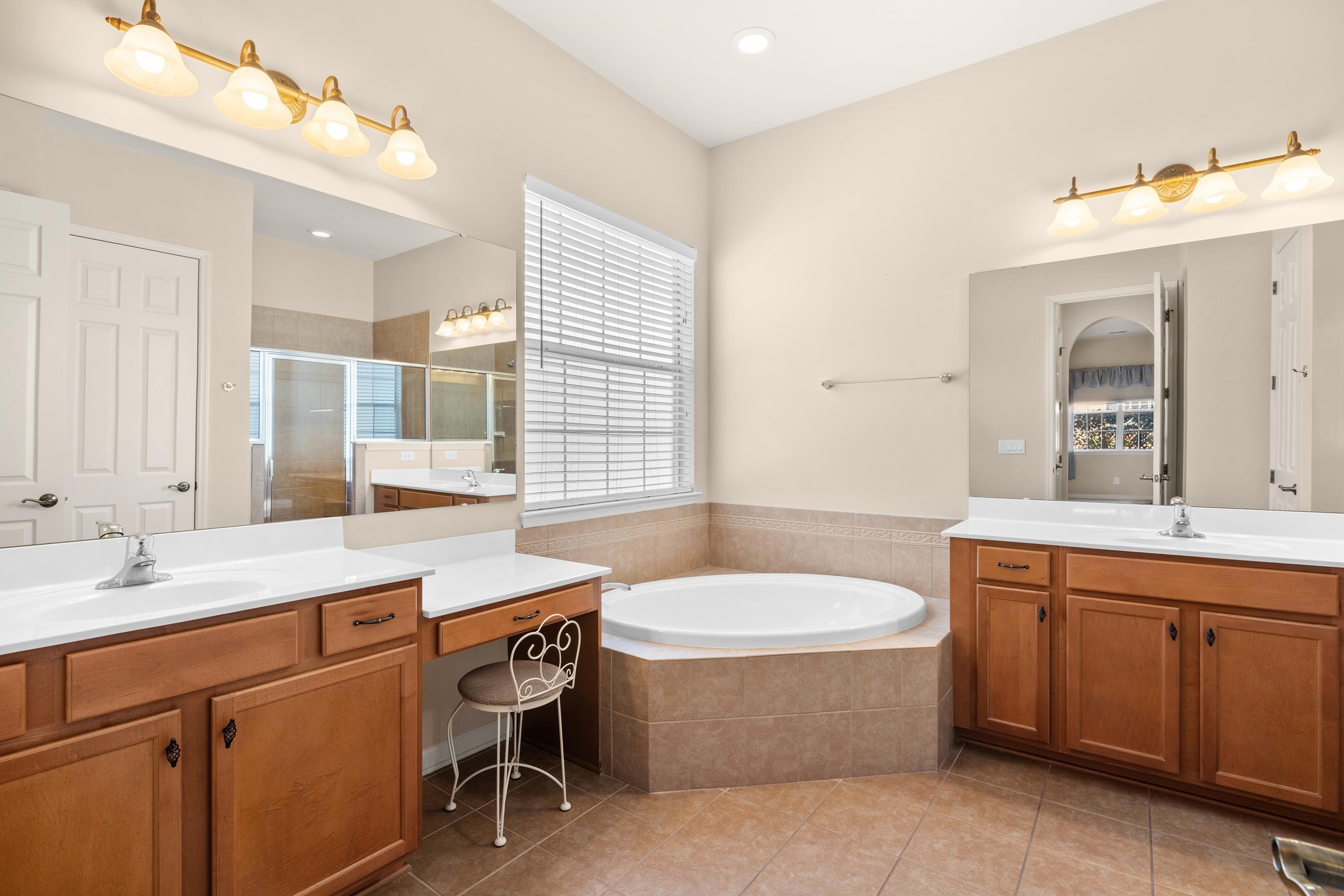 1006 Nittany Court Murrells Inlet, SC 29576 - Photo 28 of 39 Garden tub, separate vanities and sinks, linen closet, and a tiled shower with a glass enclosure, and tile flooring.