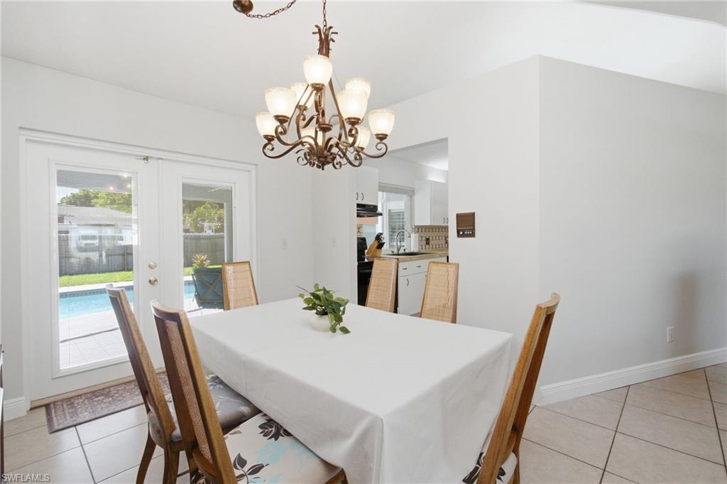 3022 47th Street Southwest Naples, FL 34116 - Photo 11 of 46 Dining area featuring a decorative chandelier and tiled flooring
