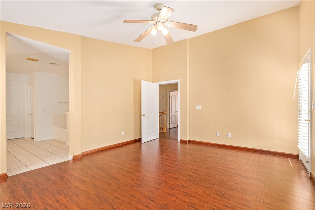 1477 Rancho Ridge Drive Henderson, NV 89012 - Photo 19 of 46 A well-lit bedroom features rich wood flooring and a refreshing ceiling fan.
