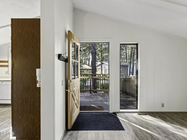 a view of a hallway with wooden floor and a living room