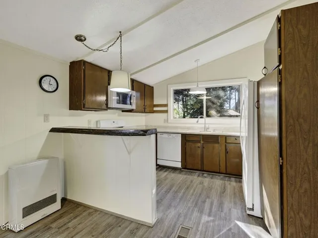 a kitchen with stainless steel appliances granite countertop a sink cabinets and wooden floor
