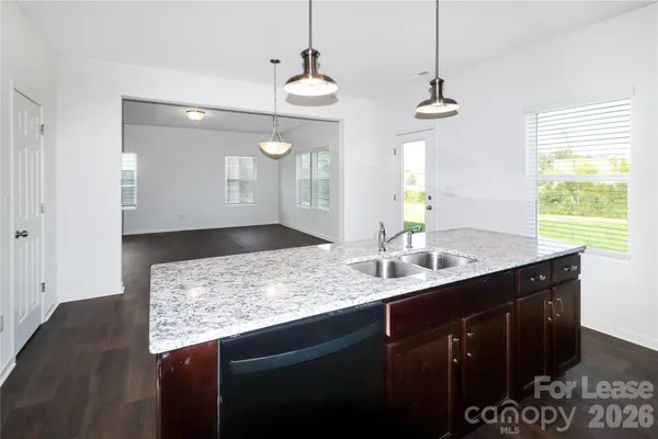 a bathroom with a granite countertop sink a toilet and a mirror