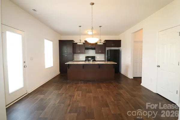 a view of a kitchen with a sink and dishwasher a refrigerator with wooden floor
