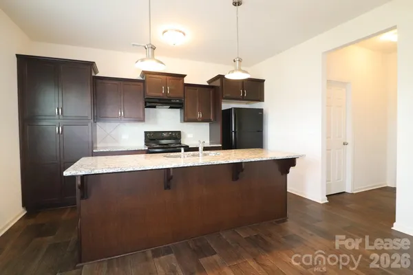 a kitchen with stainless steel appliances granite countertop a refrigerator a sink and a stove