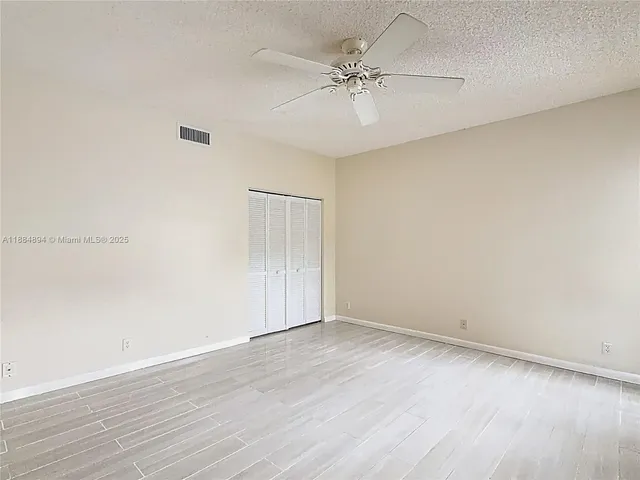 a view of house with a big yard and large trees