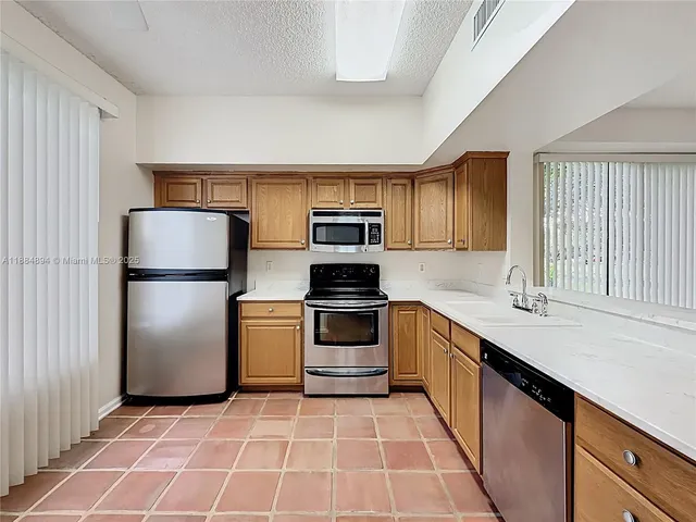 a kitchen with stainless steel appliances granite countertop a refrigerator sink and cabinets