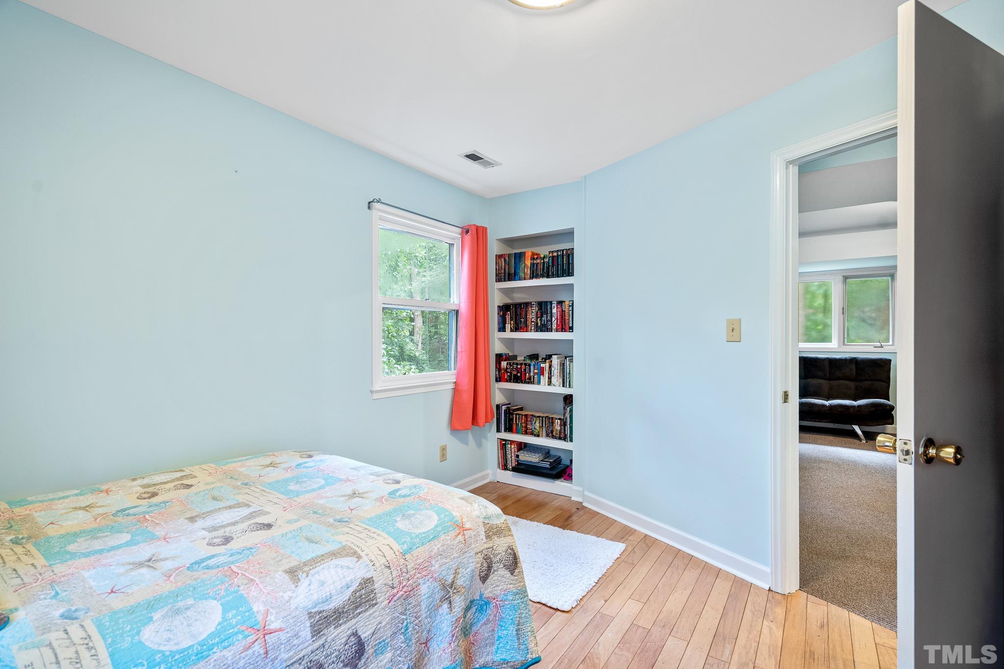 8808 Red Oak Court Raleigh, NC 27613 - Photo 3 of 34 a bedroom with a bed and a bookshelf