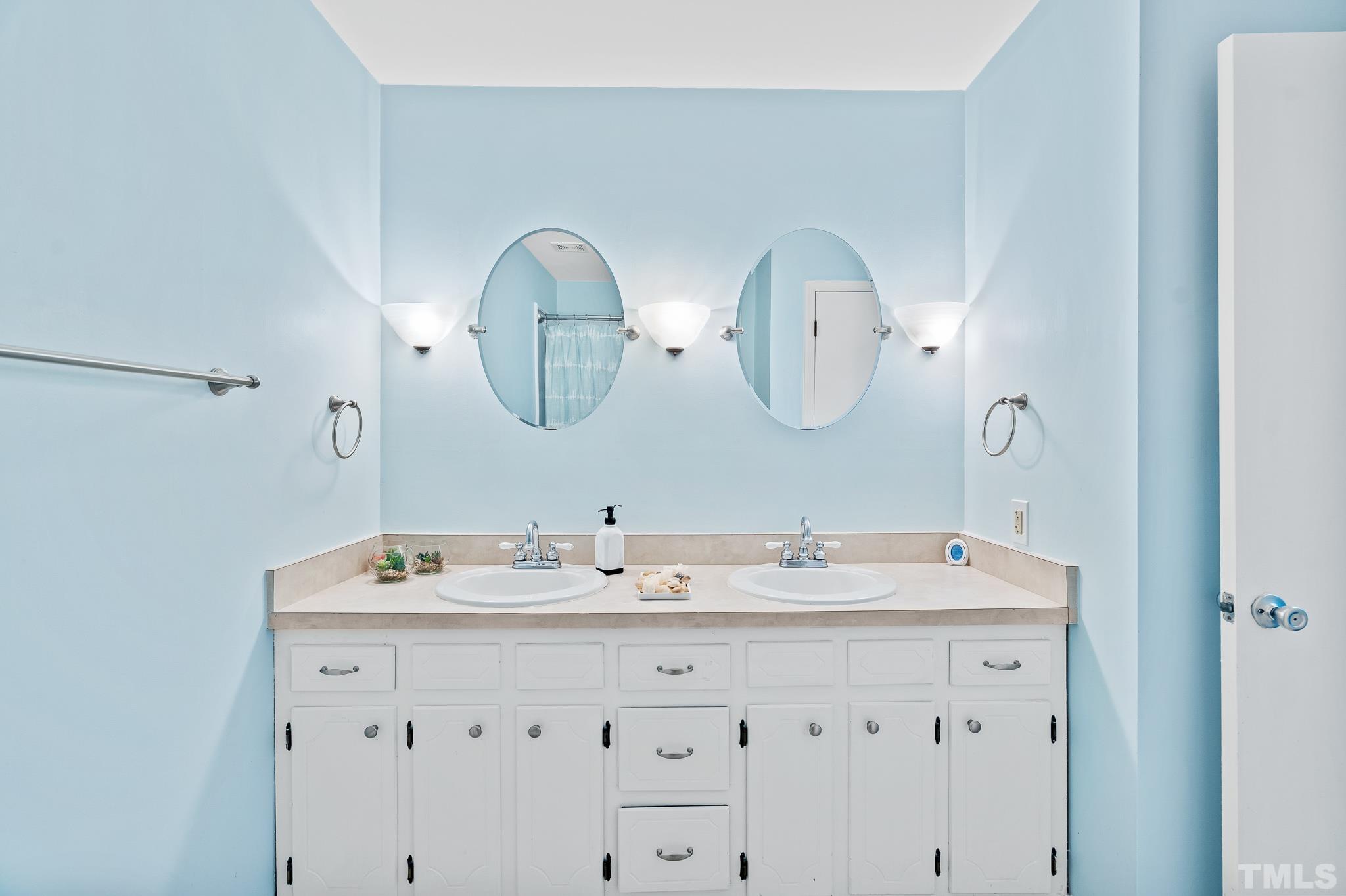 8808 Red Oak Court Raleigh, NC 27613 - Photo 8 of 34 a bathroom with a double vanity sink and a mirror
