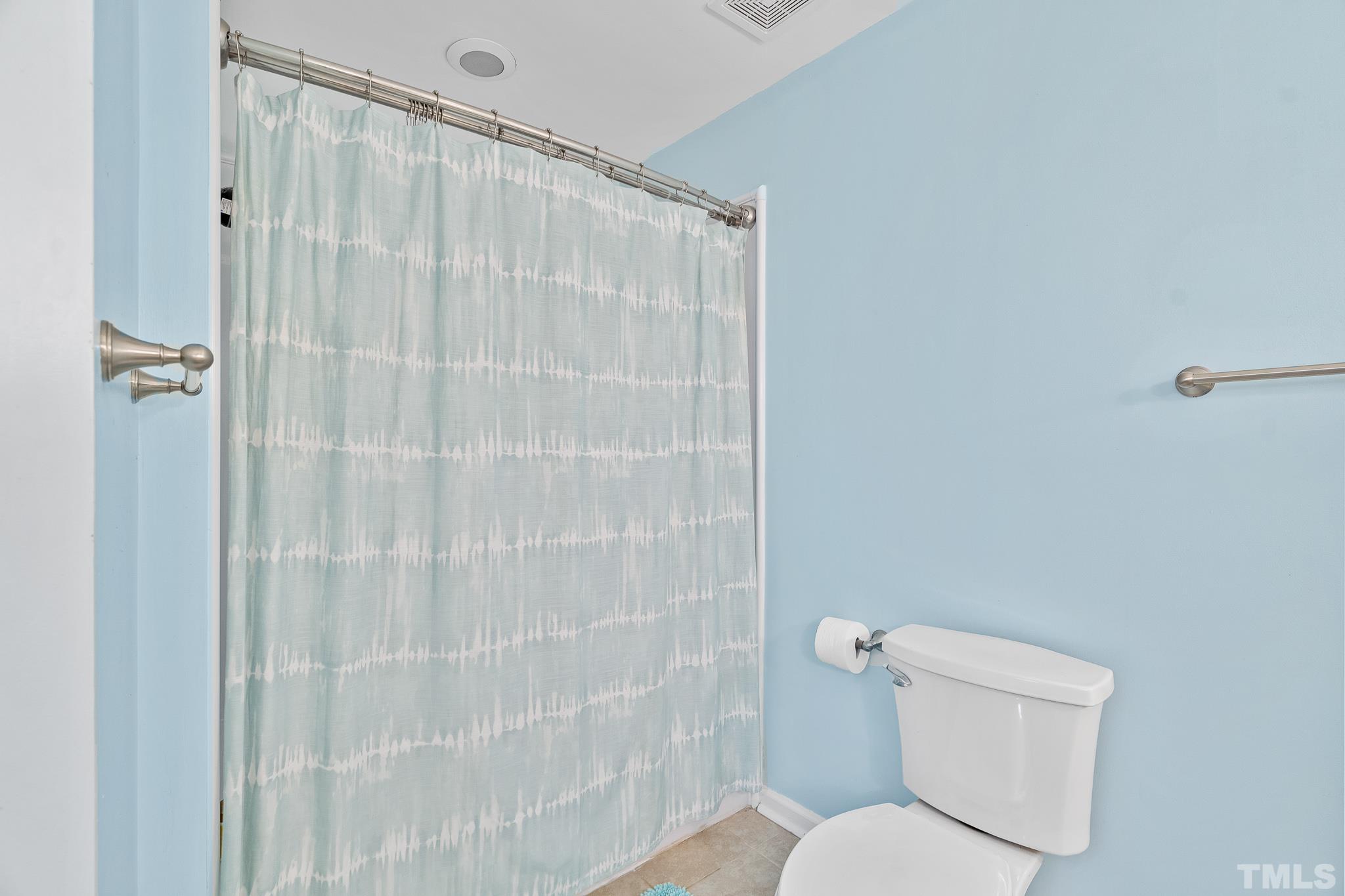 8808 Red Oak Court Raleigh, NC 27613 - Photo 9 of 34 a white toilet sitting next to a shower curtain
