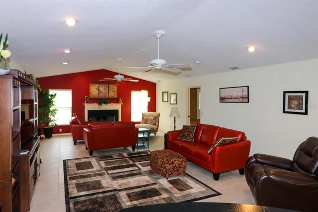 a living room with furniture a fireplace and a chandelier