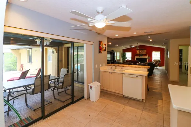 a room with chandelier fan and white walls