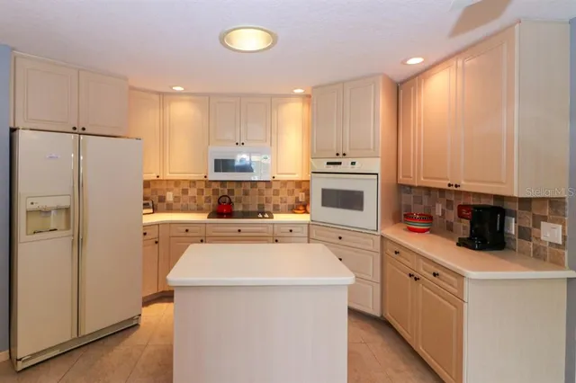 a kitchen with a refrigerator a stove top oven a sink and cabinets