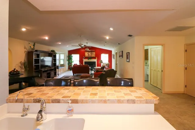 a living room with stainless steel appliances kitchen island granite countertop a couch and a view of living room