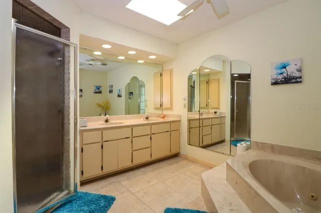 a bathroom with a granite countertop sink mirror and bathtub