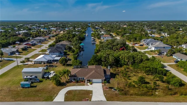 an aerial view of residential houses with outdoor space and trees