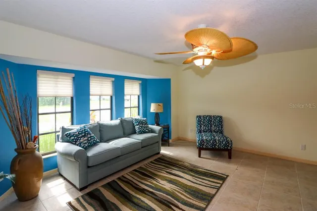 a living room with furniture a chandelier and a window