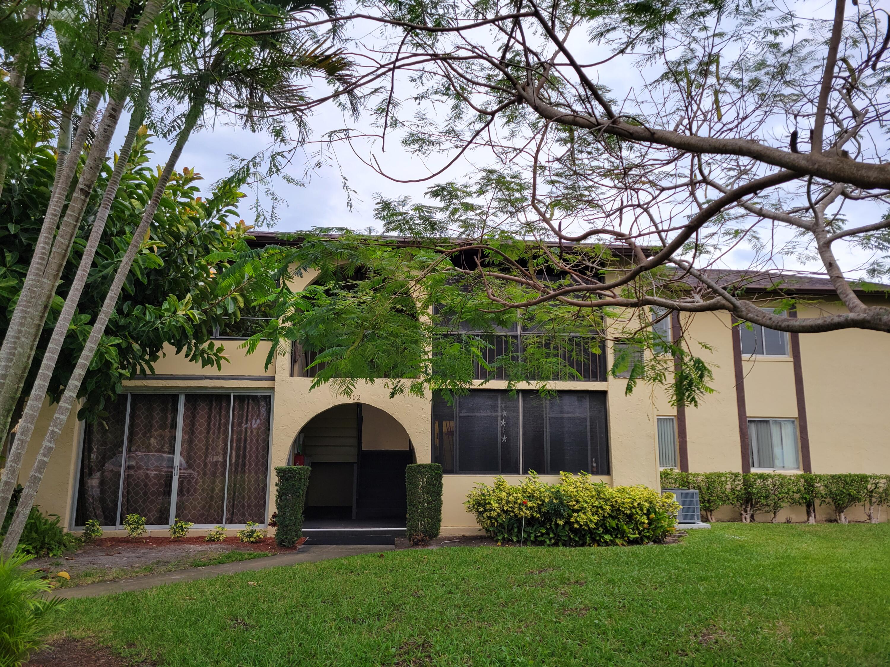 302 Pine Ridge Circle, Unit D2 Greenacres, FL 33463 - Photo 2 of 20 a front view of a house with garden