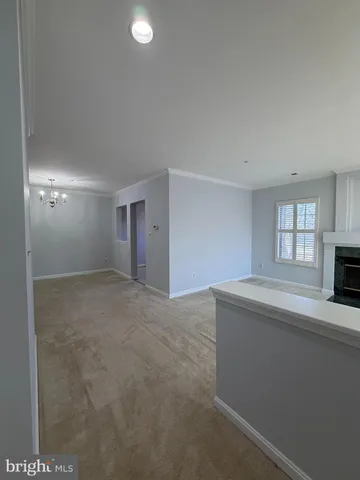 a view of an empty room with a fireplace and a window