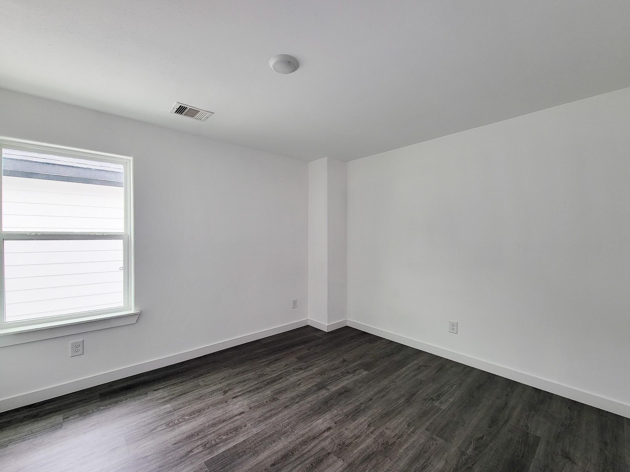 8122 Sterlingshire Street, Unit B Houston, TX 77078 - Photo 16 of 27 an empty room with wooden floor and windows