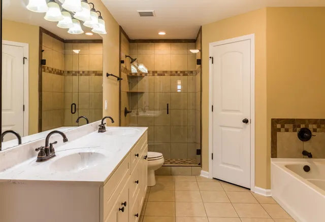 a bathroom with a sink a toilet a mirror and shower