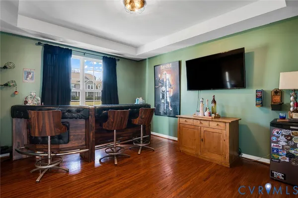 a kitchen with stainless steel appliances granite countertop a refrigerator a stove top oven a sink dishwasher a dining table and chairs with wooden floor