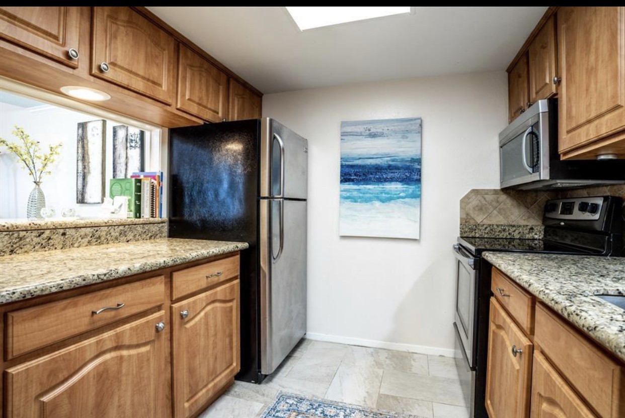2228 South Piney Point Road, Unit 101 Houston, TX 77063 - Photo 6 of 8 a kitchen with granite countertop cabinets stainless steel appliances and a counter space