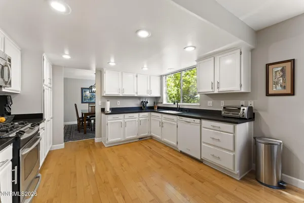 a large kitchen with stainless steel appliances granite countertop a stove a sink and a refrigerator