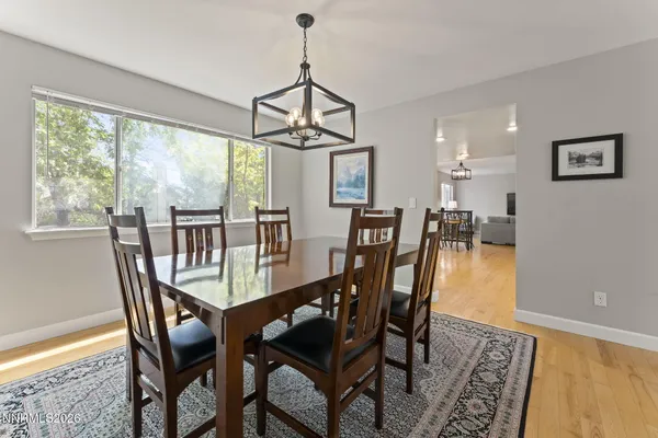a dining room with furniture window and wooden floor