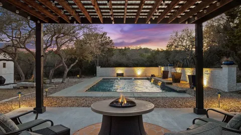a backyard of a house with fire pit and outdoor seating