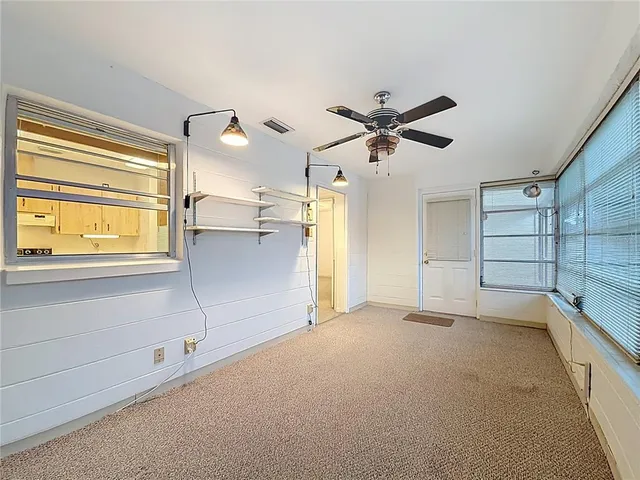 a view of a livingroom with a ceiling fan and window