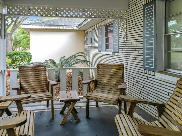 a view of a patio with table and chairs with wooden floor and fence