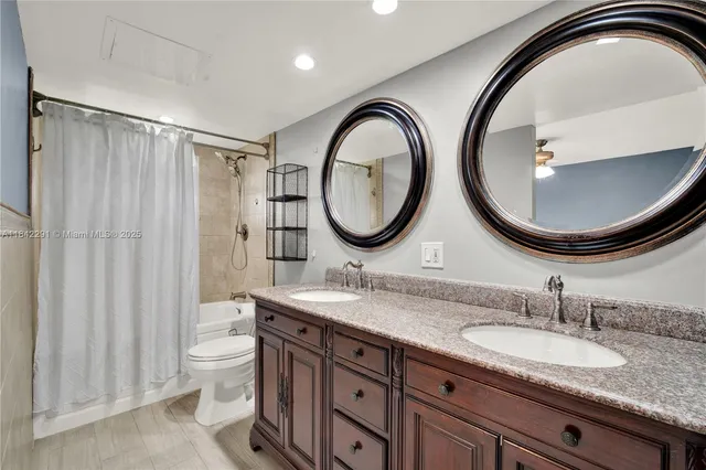 a bathroom with a granite countertop double vanity sink and a mirror