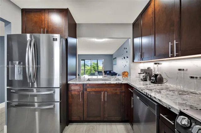a kitchen with granite countertop stainless steel appliances and refrigerator