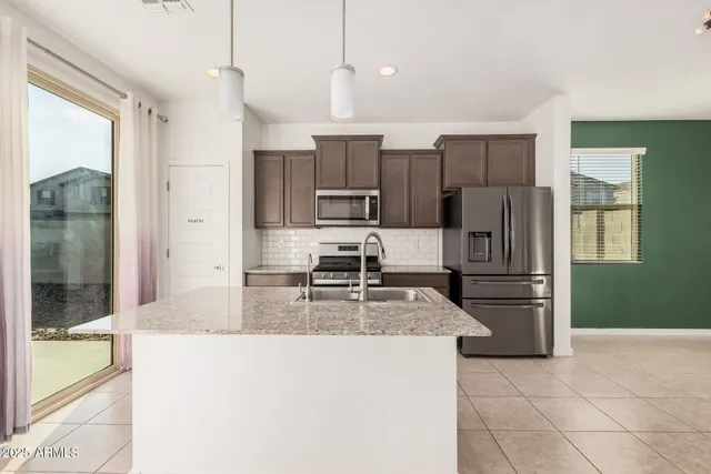 a kitchen with kitchen island a counter top space a refrigerator and cabinets