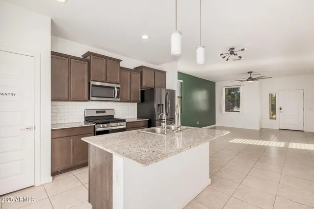 a kitchen with kitchen island a sink stainless steel appliances and cabinets