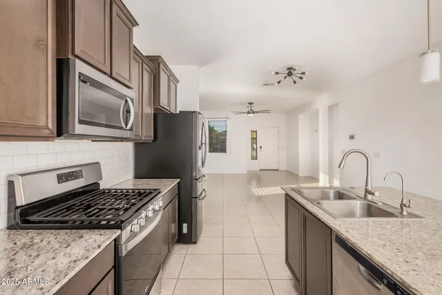 a kitchen with stainless steel appliances granite countertop a sink stove and refrigerator