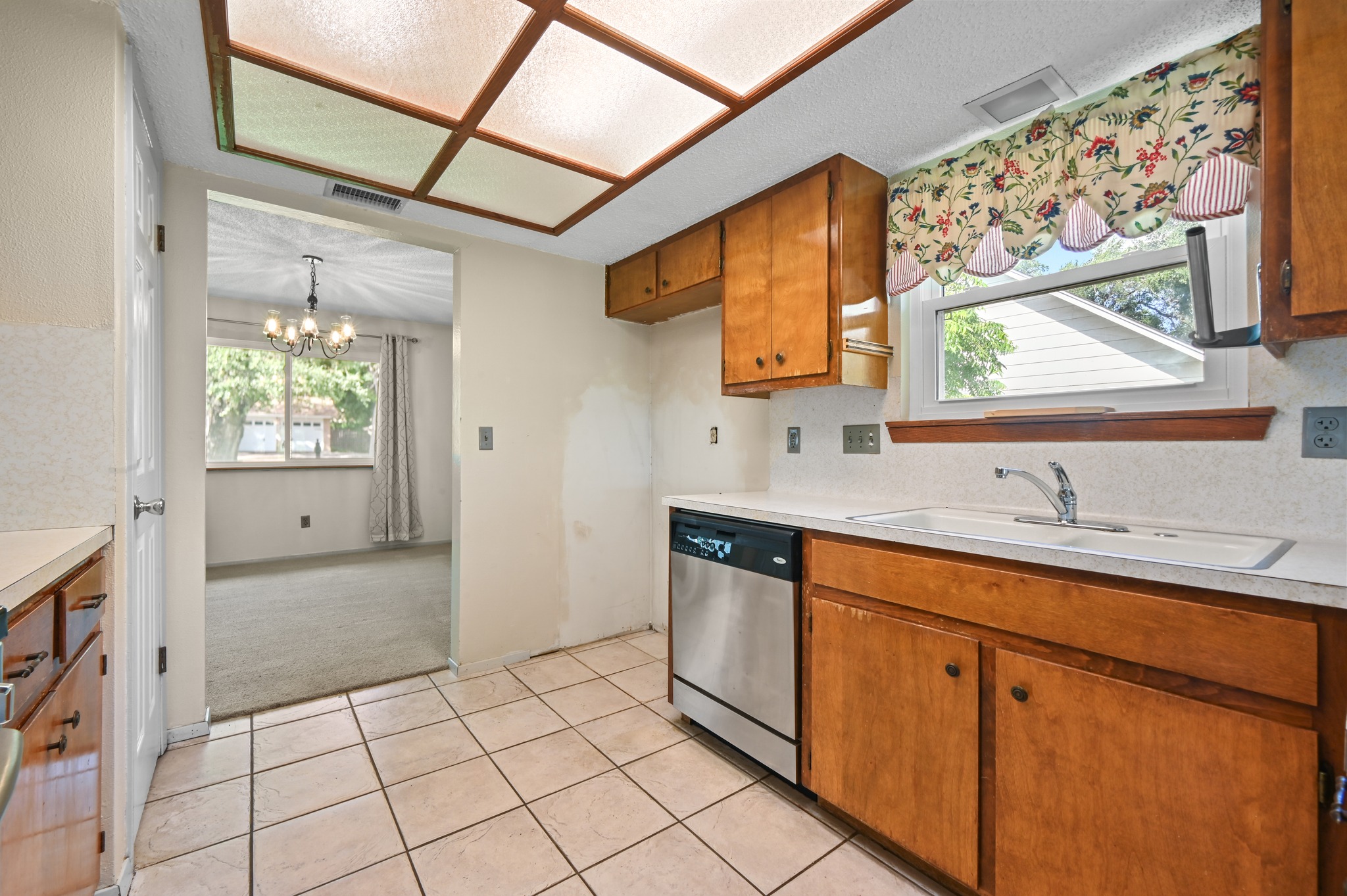 10504 Hard Rock Road Austin, TX 78750 - Photo 12 of 28 A view of the kitchen, featuring an integrated sink, ample cabinetry, and a dishwasher.