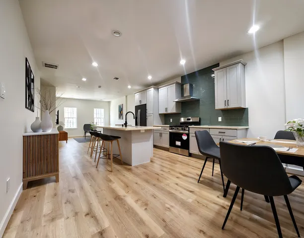 a living room with furniture a flat screen tv and kitchen view
