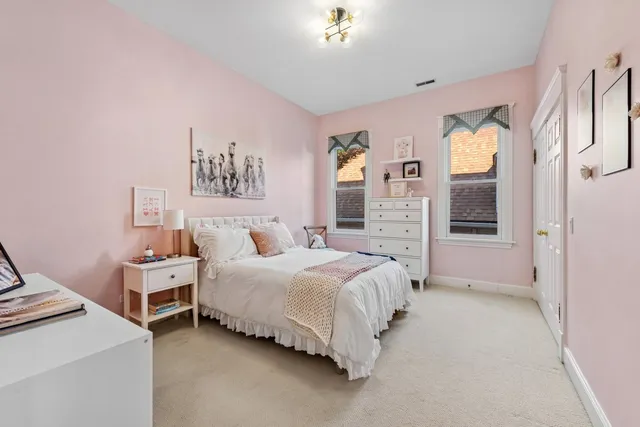 a bedroom with a bed and a lamp on dresser