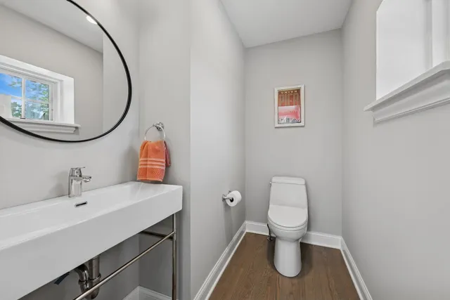 a bathroom with a toilet a sink and mirror