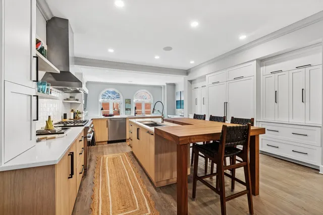 a kitchen with stainless steel appliances granite countertop a lot of counter space and wooden floors