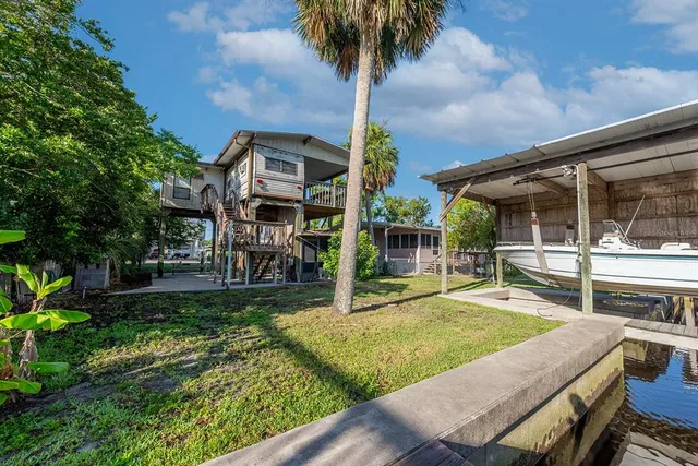 a view of a house with backyard and sitting area